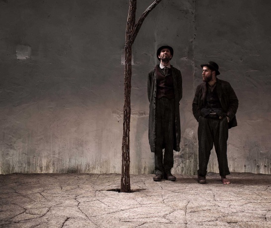 A production photo of Waiting for Godot by Samuel Beckett featuring Marty Rea and Aaron Monaghan standing alongside a metal tree.