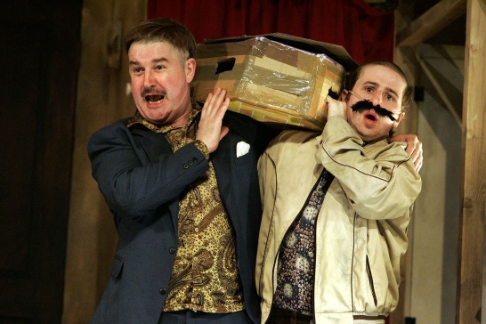 A production photo from The Walworth Farce by Enda Walsh featuring Denis Conway and Aaron Monaghan holding a cardboard coffin.