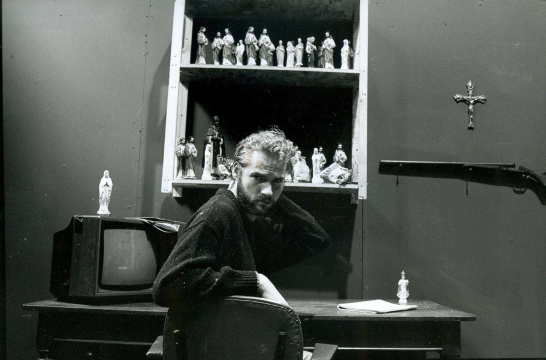 A black-and-white photo of playwright Martin McDonagh on the set of The Lonesome West.