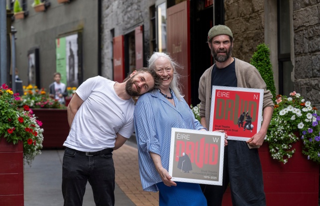 Aaron Monaghan (Druid Ensemble), Marie Mullen (Druid Co-Founder) and Marty Rea (Druid Ensemble) photographed on Druid Lane holding large prints of Druid's two 50th anniversary special stamps from An Post.