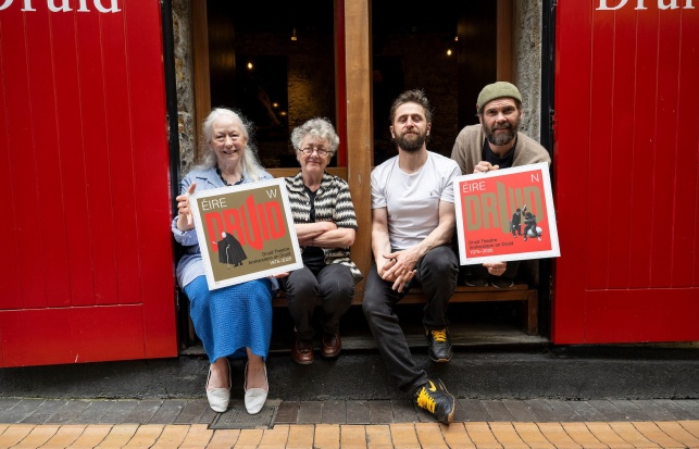 Druid Co-Founders Marie Mullen and Garry Hynes with Druid Ensemble members Aaron Monaghan and Marty Rea photographed on Druid Lane holding large prints of Druid's special 50th anniversary stamps from An Post.