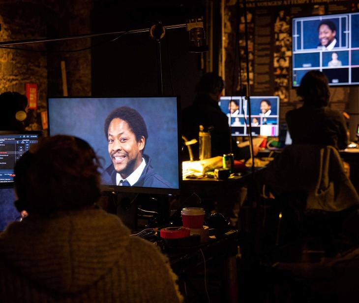 A behind the scenes photo of Druid's first live streamed production, Once Upon a Bridge by Sonya Kelly, featuring actor Adetomiwa Edun on a bank of screens in the foyer of The Mick Lally Theatre.