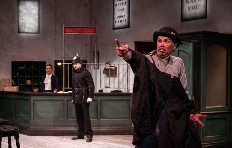 A production photo from A Pound on Demand, part of Three Short Comedies by Seán O'Casey, featuring actors Venetia Bowe and Liam Heslin in the background on left and actor Marty Rea in the foreground on right