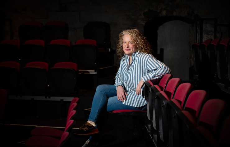 Lianne O'Shea, the 2025 recipient of Druid's Marie Mullen Bursary, seated inside The Mick Lally Theatre on Druid Lane in Galway.